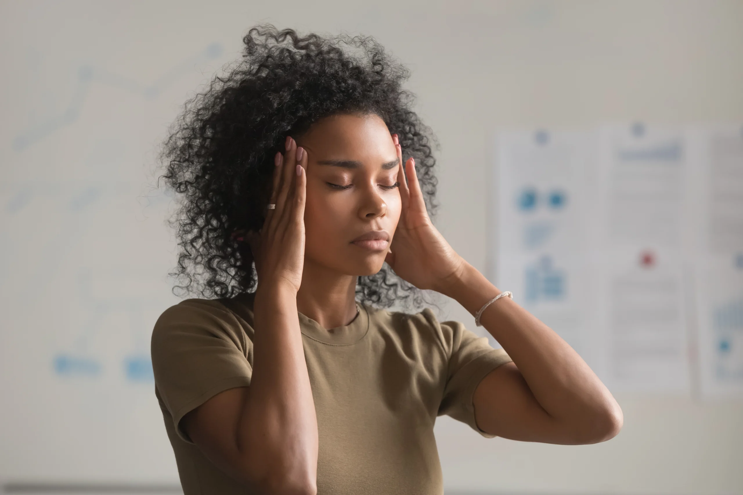 Person holding head in discomfort with blood sugar symbols, illustrating link between high glucose and headaches