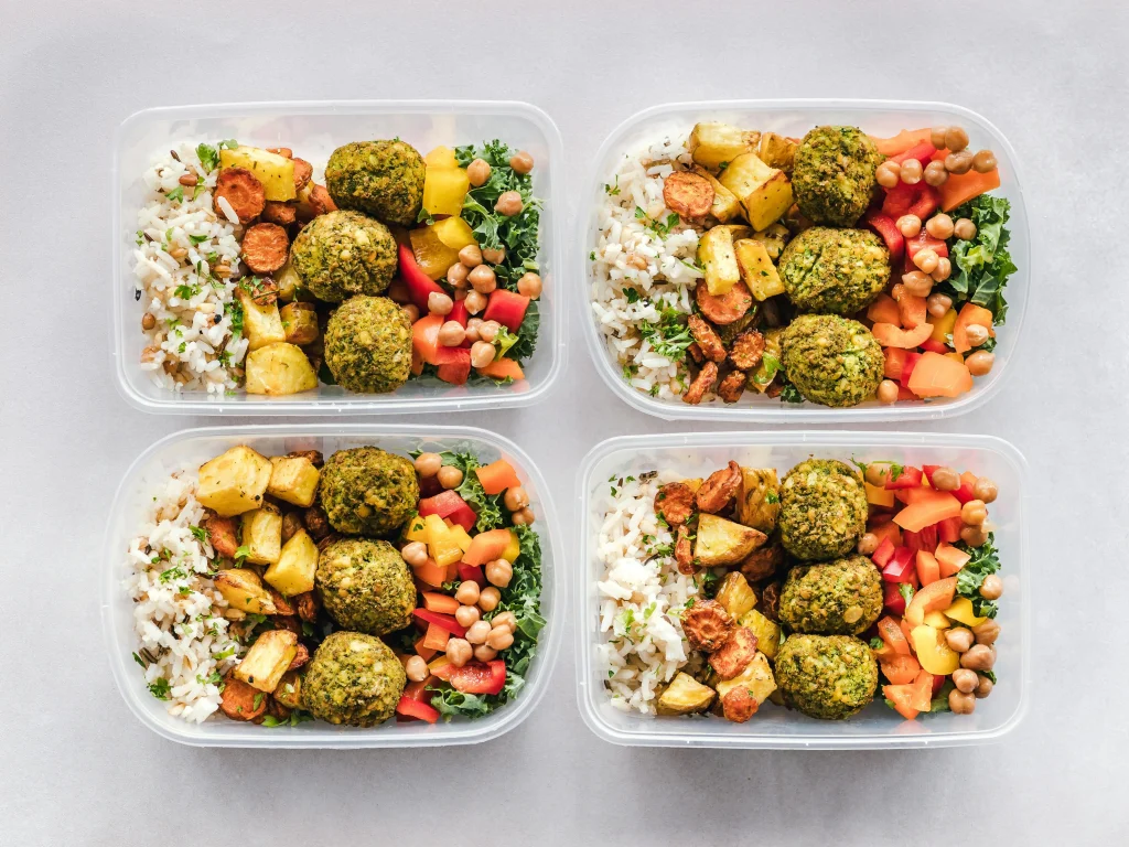 Meal prep for diabetes: plated meals in containers held by individual for portion control