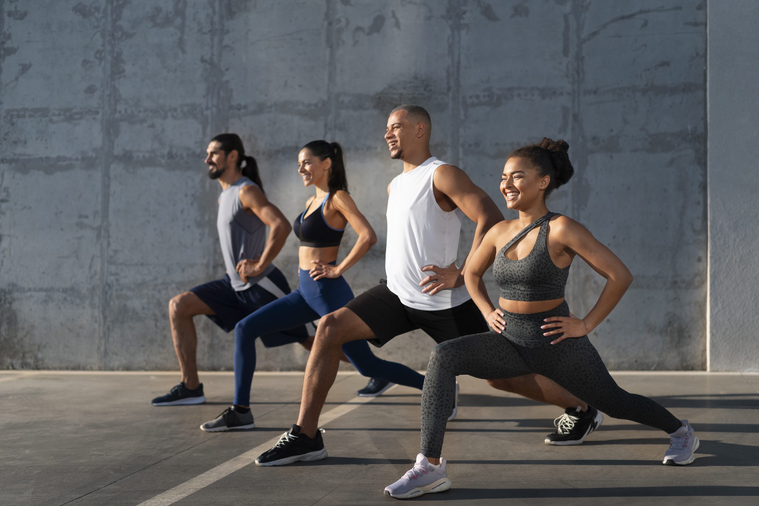 Four people doing lunges outdoors with smiles, illustrating effective exercise strategies for managing Type 1 diabetes in 2025.
