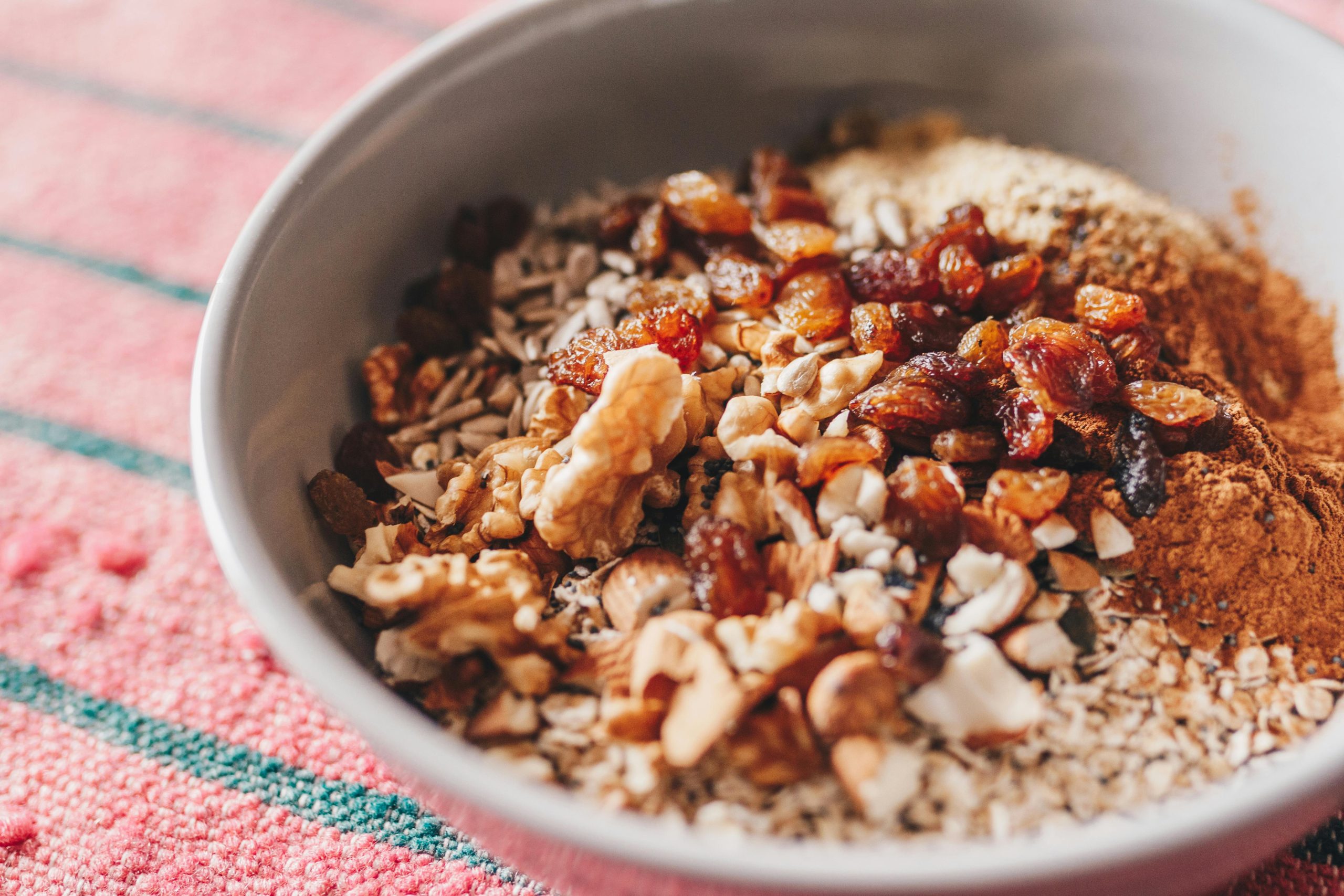 A bowl of oats, nuts, and raisins highlighting a nutritious choice in the guide to high-fiber foods that help lower blood sugar.