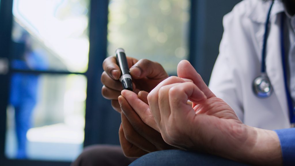 Doctor holding a pen while examining his phone, highlighting the importance of proper glucometer calibration.